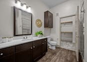 Thumbnail 4 of 36 - A bathroom with a brown cabinet and a white sink.