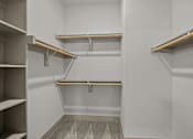 Thumbnail 6 of 36 - A white walk in closet with shelves and a carpeted floor.