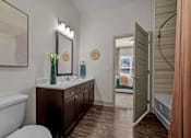Thumbnail 3 of 36 - A bathroom with a white tub and a wooden vanity.
