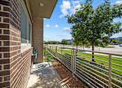 Thumbnail 12 of 36 - A tree is behind a fence in front of a building.