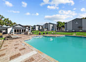 Thumbnail 14 of 17 - A swimming pool surrounded by a brick patio and a black fence.