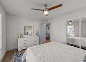 Thumbnail 11 of 17 - A white bedroom with a large bed and a ceiling fan.