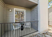Thumbnail 12 of 17 - A small balcony with a table and chairs.