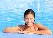 Thumbnail 7 of 24 - a young woman in a swimming pool smiling at the camera