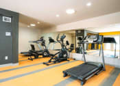 Thumbnail 21 of 27 - a gym with cardio equipment on the floor and a mirrored wall