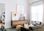 Thumbnail 2 of 22 - A modern living room with a green sofa and a wooden cabinet.