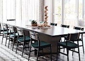 Thumbnail 11 of 22 - A long dining table with chairs and a chandelier in a room.