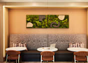 Thumbnail 19 of 22 - A modern cafe with a green leafy painting on the wall.