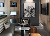 Thumbnail 8 of 22 - A modern living room with a grey sofa, a round table, and a TV.