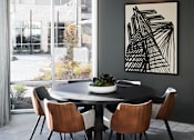 Thumbnail 20 of 22 - A dining table with chairs and a framed artwork on the wall.