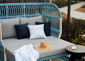 Thumbnail 12 of 22 - A blue chair with a hat on it.