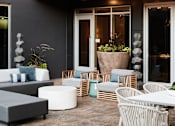 Thumbnail 13 of 22 - A patio with a table, chairs, and a potted plant.