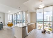 Thumbnail 44 of 76 - A dog is sitting on the floor in a modern kitchen with a view of the city.