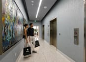 Thumbnail 14 of 76 - Two people walking down a hallway carrying shopping bags.