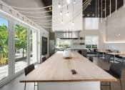 Thumbnail 23 of 66 - a large dining room with a wooden table and a kitchen in the background
