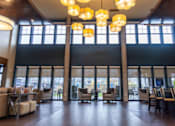 Thumbnail 8 of 14 - A large room with wooden floors and a long table with chairs.
