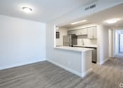 Thumbnail 26 of 44 - A kitchen area with a white counter and a refrigerator.