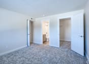 Thumbnail 21 of 44 - A room with carpeted floor and white walls with three doors.