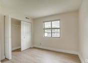 Thumbnail 6 of 44 - an empty bedroom with a closet and a window