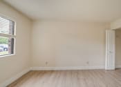 Thumbnail 12 of 44 - the living room of an empty house with wood flooring and a window