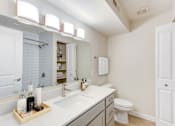 Thumbnail 44 of 44 - A bathroom with a white sink and a white toilet.
