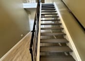 Thumbnail 15 of 44 - a set of stairs with a railing and wood floors
