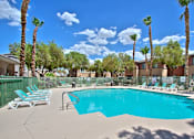 Thumbnail 8 of 16 - A swimming pool surrounded by palm trees and lounge chairs.