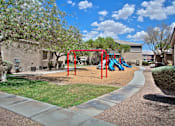 Thumbnail 5 of 16 - A playground with a red swing set and a blue slide.