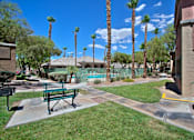 Thumbnail 1 of 16 - A park with a bench and palm trees.