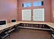 Thumbnail 10 of 16 - A room with a desk, chairs, and two monitors.