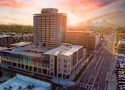 Thumbnail 1 of 50 - A cityscape with a large building in the foreground and a sunset in the background. at Denver Metro Village Apartments, Denver, CO