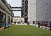 Thumbnail 7 of 50 - A small grassy area with a bench in front of a building at Denver Metro Village Apartments, Colorado, 80204