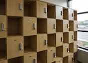 Thumbnail 19 of 50 - A series of wooden lockers with metal handles and a key slot at Denver Metro Village Apartments, Denver, CO