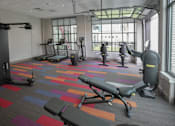 Thumbnail 23 of 50 - A gym with a variety of equipment including treadmills, weights, and exercise machines at Denver Metro Village Apartments, Denver, CO, 80204