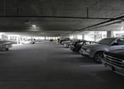 Thumbnail 17 of 50 - A parking garage with several cars parked in it at Denver Metro Village Apartments, Denver