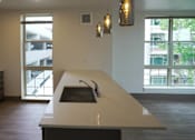 Thumbnail 25 of 50 - A modern kitchen with a large island and a view of the outside at Denver Metro Village Apartments, Denver, CO, 80204