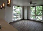 Thumbnail 22 of 50 - A room with a table, chairs, and a window overlooking a tree-filled area at Denver Metro Village Apartments, Denver, CO