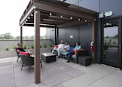 Thumbnail 10 of 50 - A group of people are sitting on a patio at Denver Metro Village Apartments, Colorado, 80204