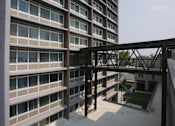 Thumbnail 5 of 50 - A modern building with a metal walkway connecting the floors at Denver Metro Village Apartments, Denver, Colorado