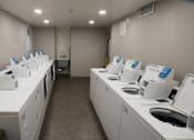 Thumbnail 39 of 50 - A laundromat with rows of washers and dryers at Denver Metro Village Apartments, Colorado