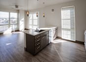 Thumbnail 33 of 50 - A kitchen with a large island and a fan at Denver Metro Village Apartments, Denver
