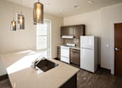Thumbnail 31 of 50 - A kitchen with a sink, stove, and refrigerator at Denver Metro Village Apartments, Denver