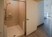 Thumbnail 48 of 50 - A bathroom with a walk in shower and a white door at Denver Metro Village Apartments, Colorado, 80204