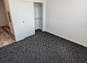 Thumbnail 17 of 20 - A room with a carpeted floor and a ceiling fan.