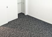 Thumbnail 18 of 20 - A room with a ceiling fan and carpeted floor.