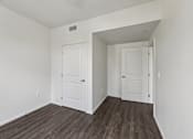 Thumbnail 17 of 42 - A room with two white doors and a wooden floor.