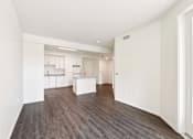 Thumbnail 10 of 42 - A large empty room with wood flooring and white walls.