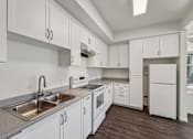 Thumbnail 26 of 42 - A kitchen with white cabinets and a stainless steel sink.