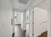 Thumbnail 40 of 42 - A hallway with white doors and a window.