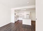 Thumbnail 32 of 42 - A kitchen with white cabinets and a wooden floor.
